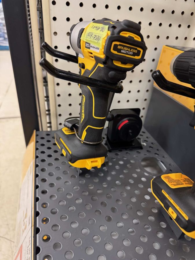 Power drill secured to a retail display using a recoiler security tether from RTF Global