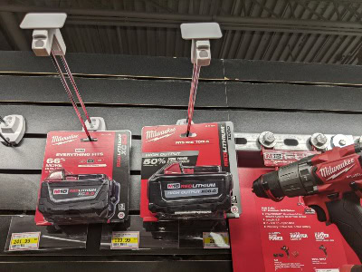 Power tool battery protected from theft by a peg hook